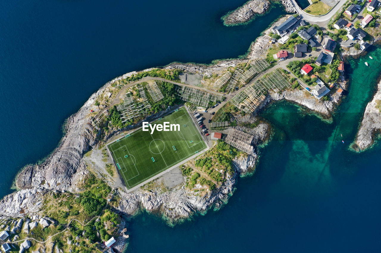 Drone view of a football field surrounded by ocean and cliffs in lofoten norway
