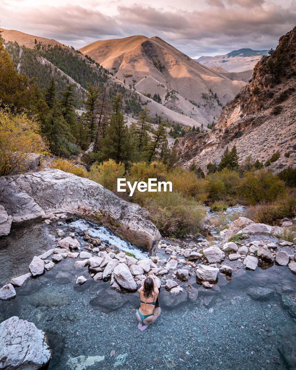 Woman in hot spring pools in mountains with a view