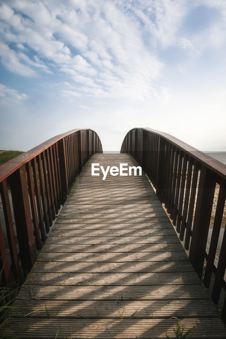 View of empty footbridge against sky