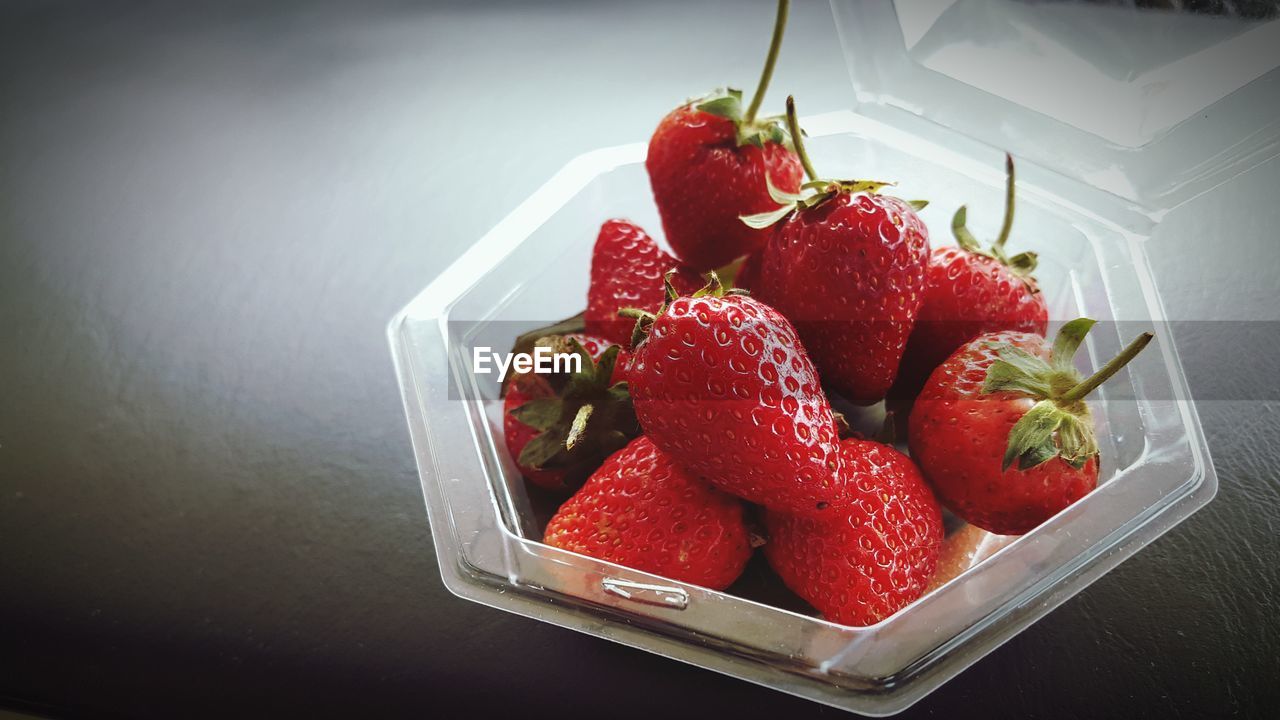 HIGH ANGLE VIEW OF STRAWBERRIES ON TABLE