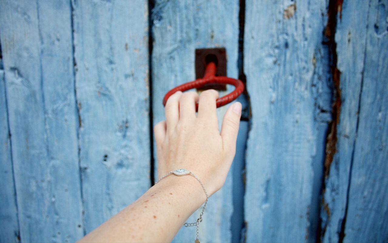 Close-up of hand with key in door