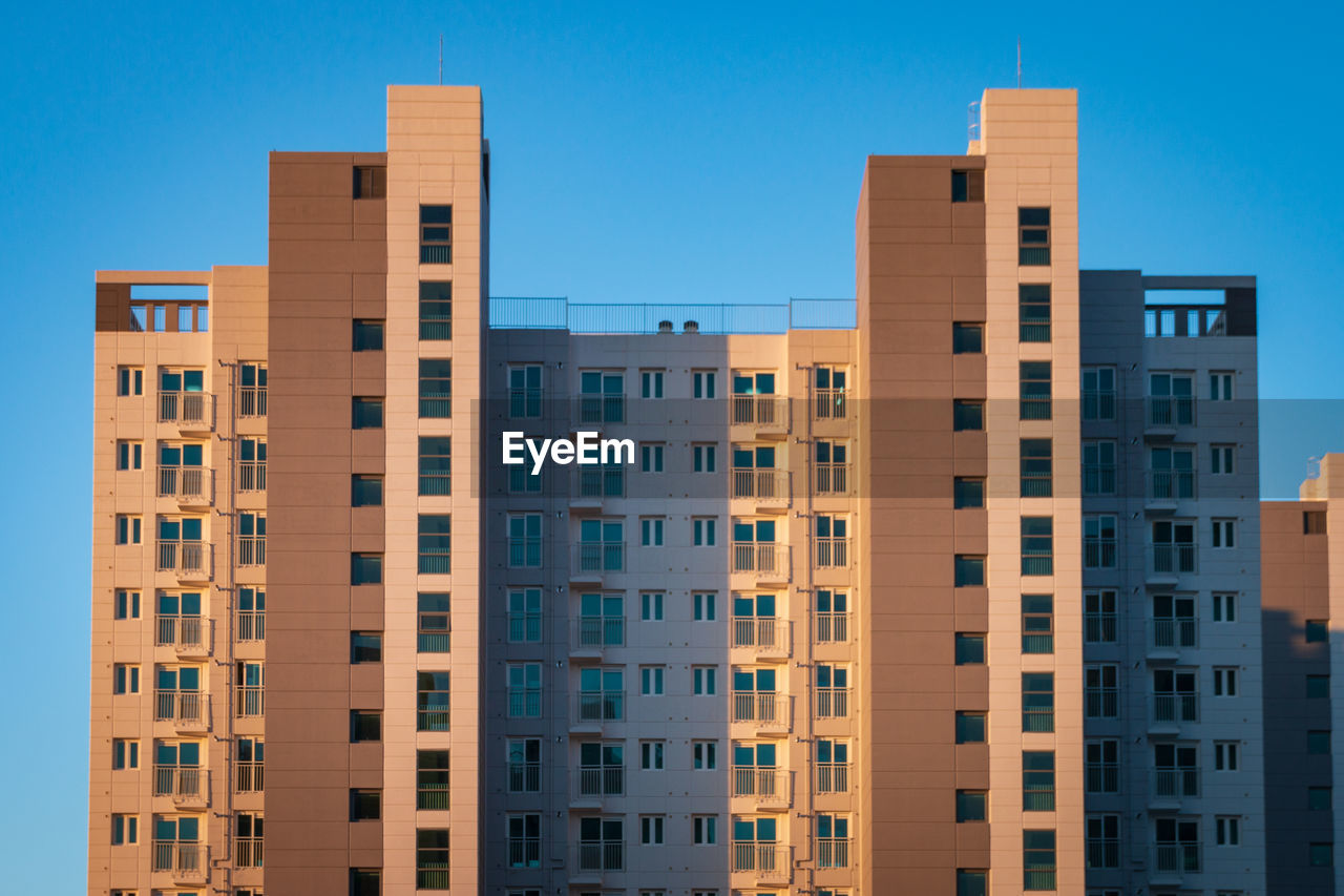 View of an apartment tower in front of a blue sky in south korea