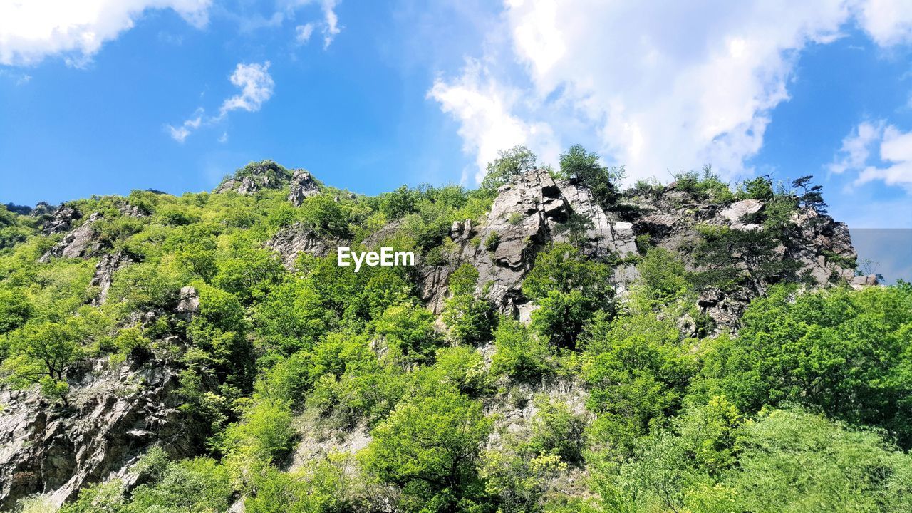 Low angle view of hill against cloudy sky