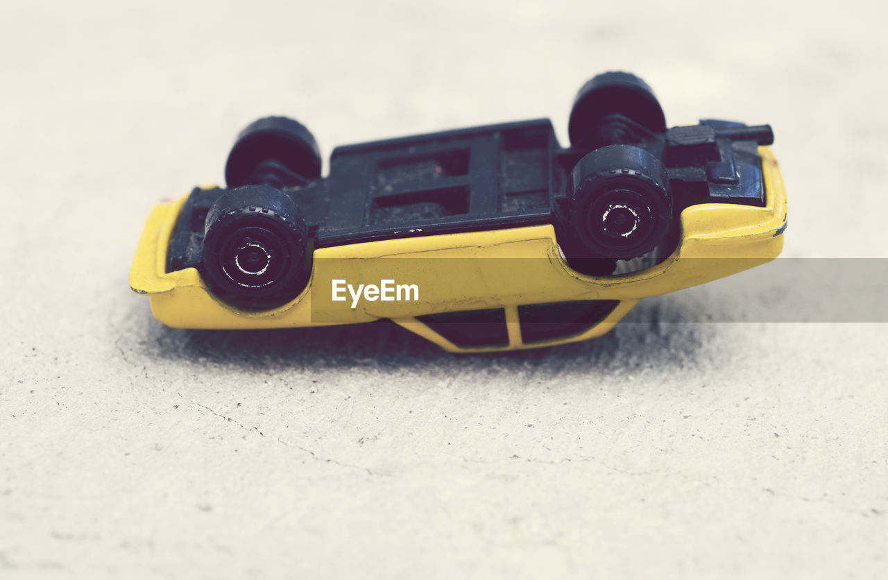 Close-up of yellow toy car on floor