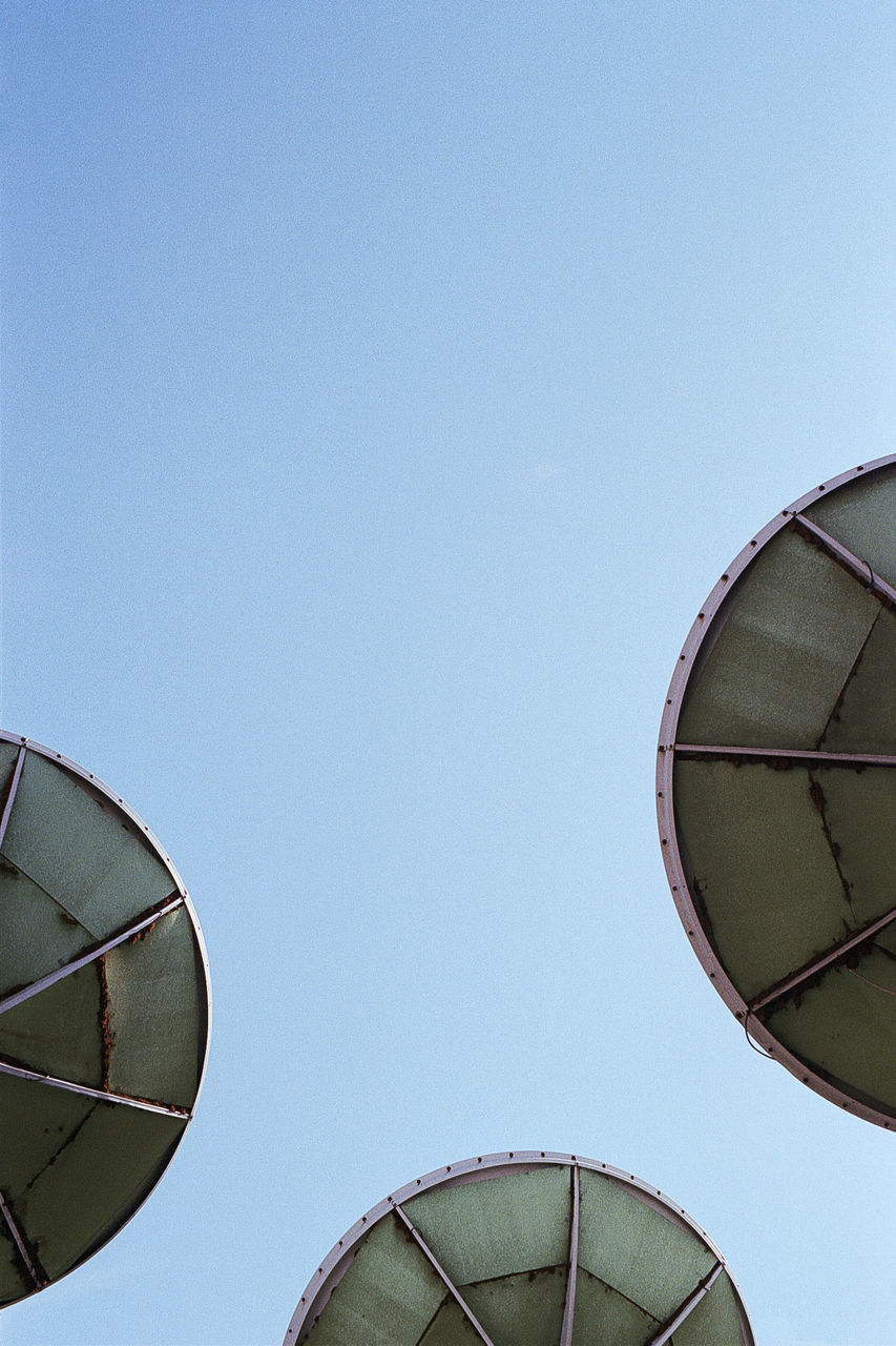 Directly below shot of satellite dishes against clear blue sky