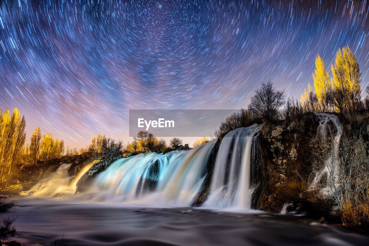 Long exposure of waterfall against sky at night