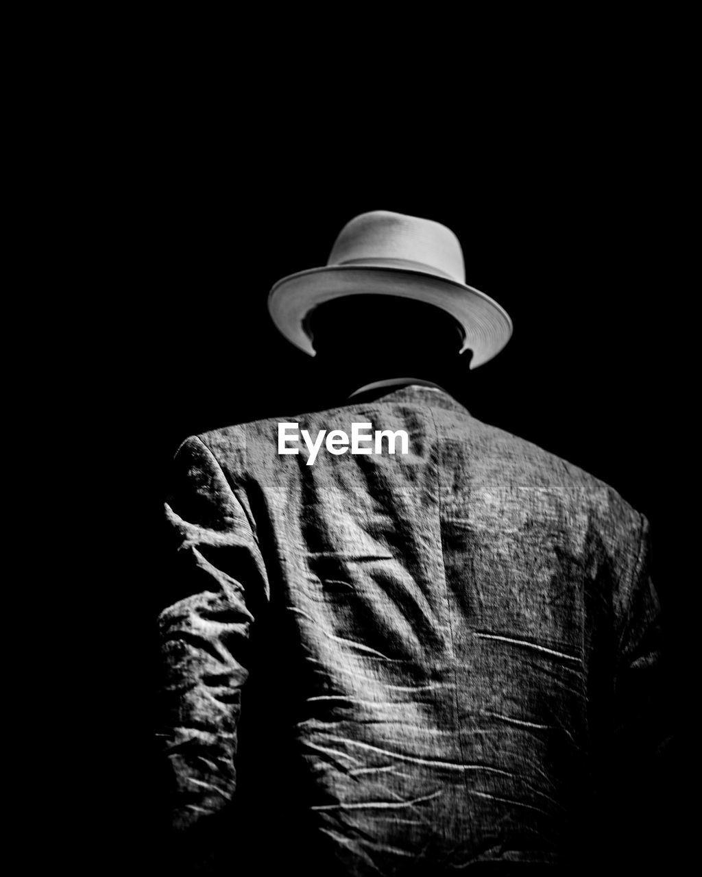 Rear view of man wearing hat against black background