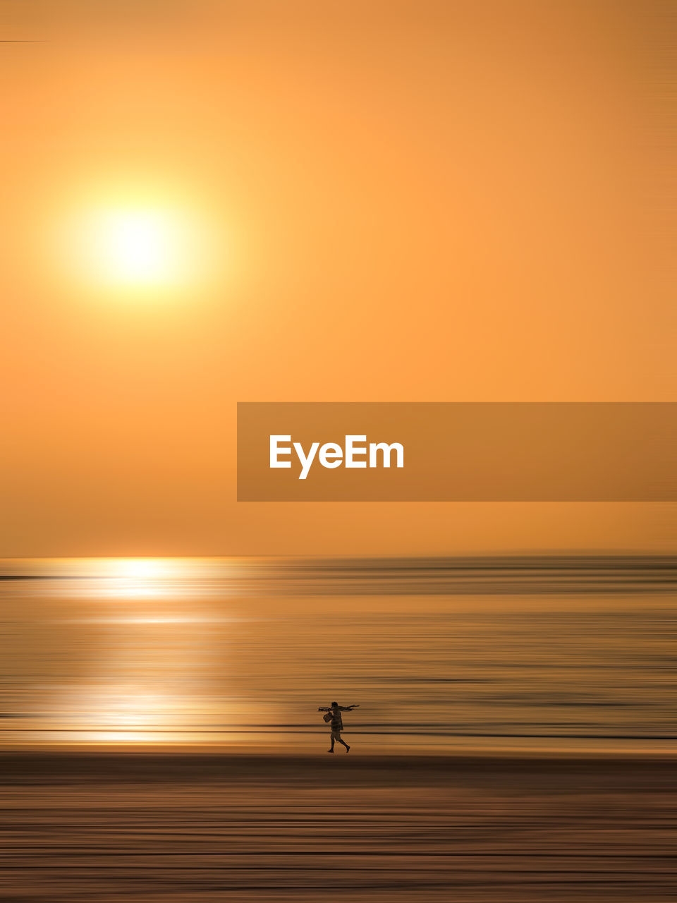 Man walking at beach during sunset