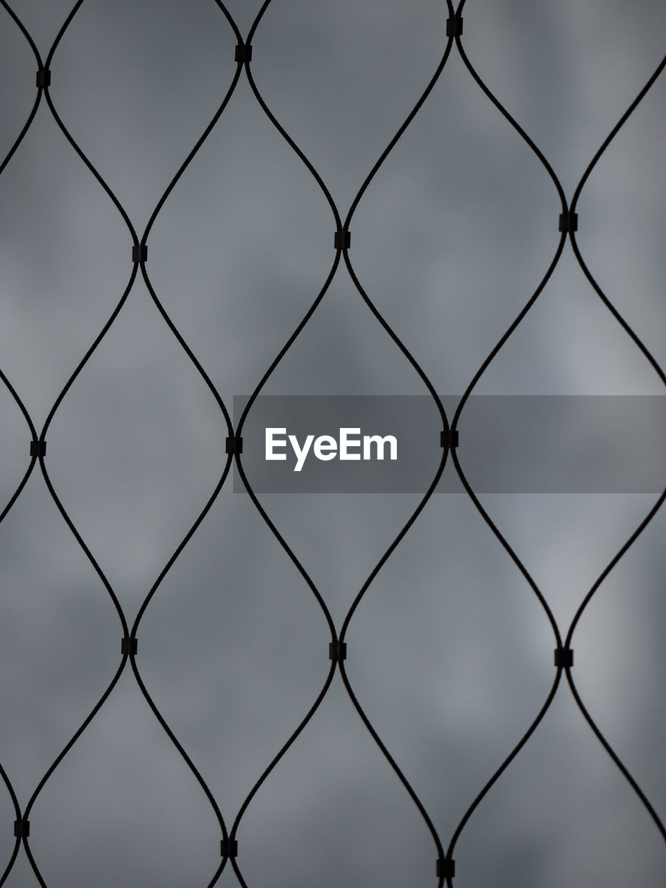 Iron wire fence. web. riveted twirl steel wire fence in rainy weather