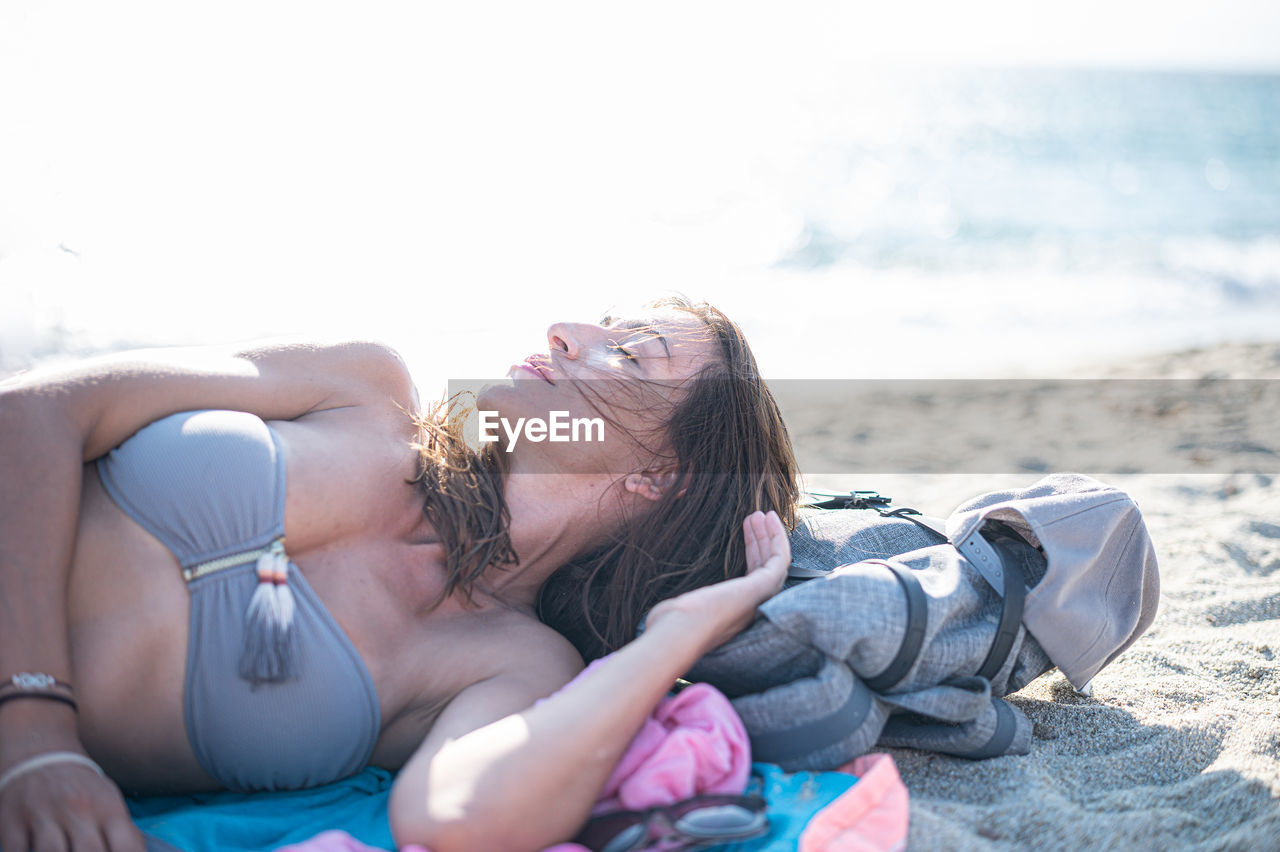 Woman in bikini lying on beach