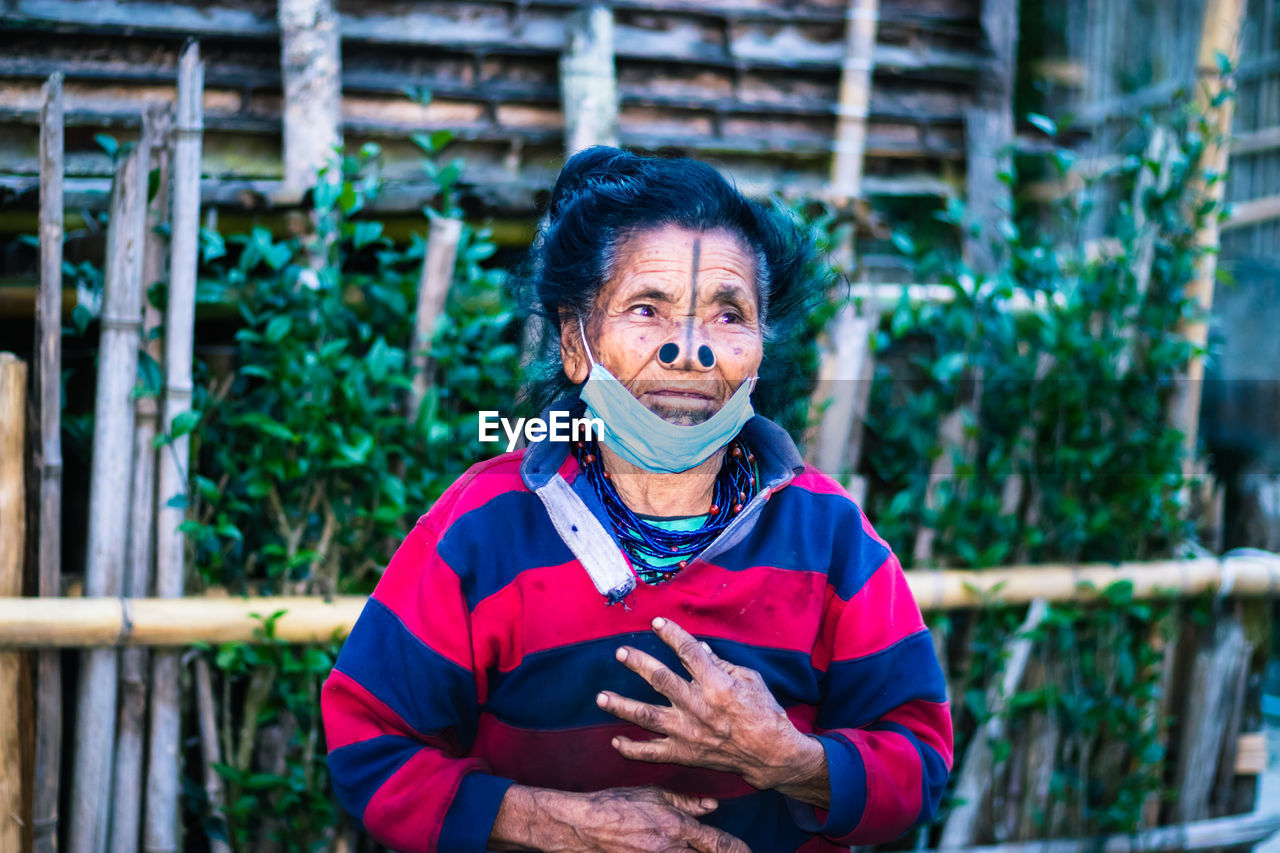 Apatani tribal women facial expression with her traditional nose lobes and blurred background