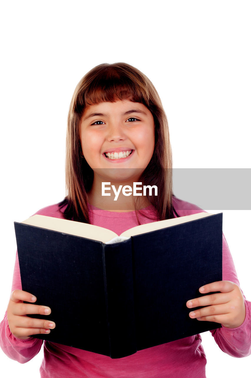 PORTRAIT OF A SMILING YOUNG WOMAN ON BOOK