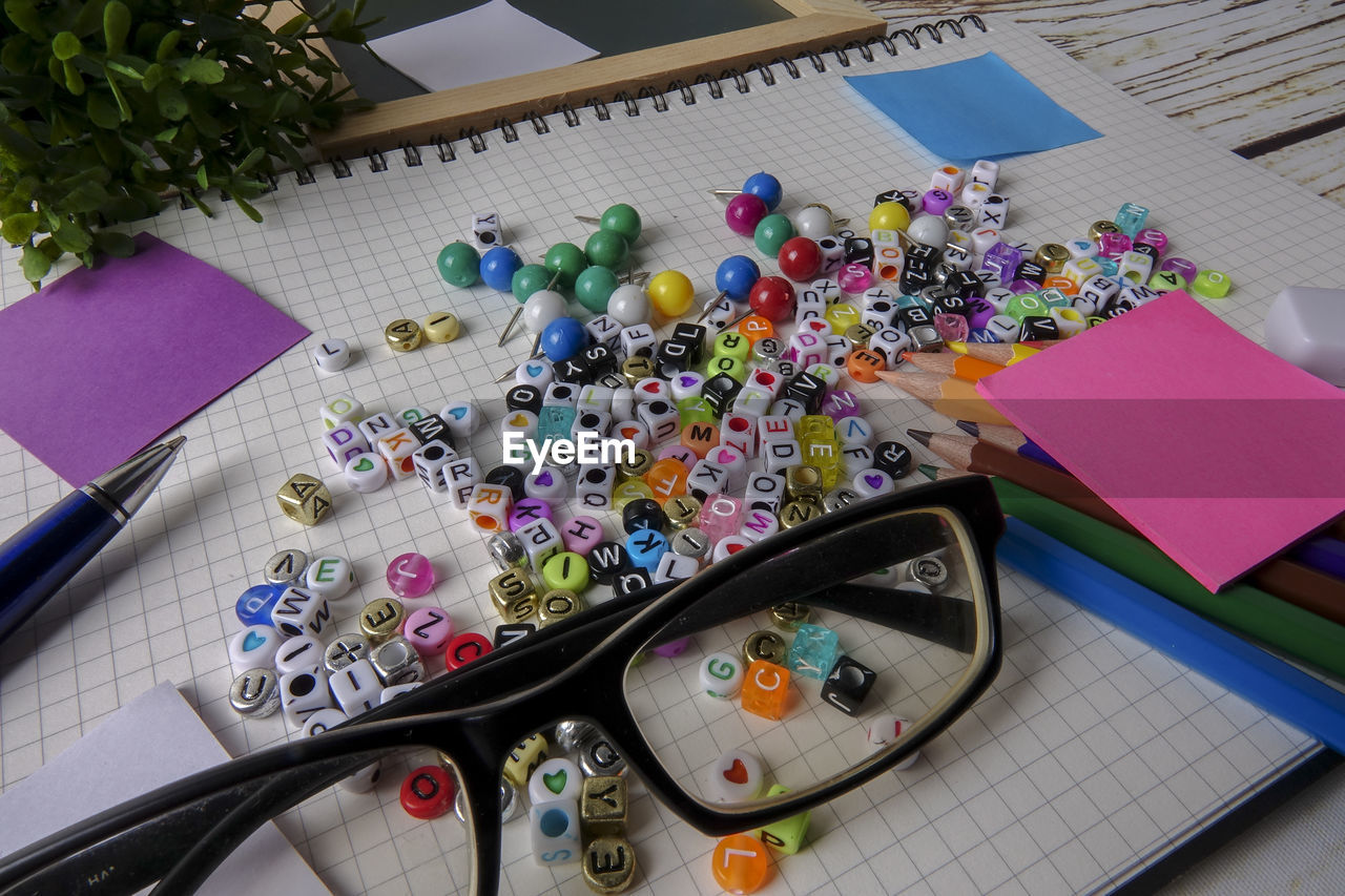 High angle view of alphabet beads with school supplies on table