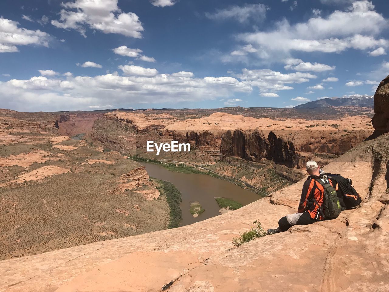 People sitting on mountain against sky