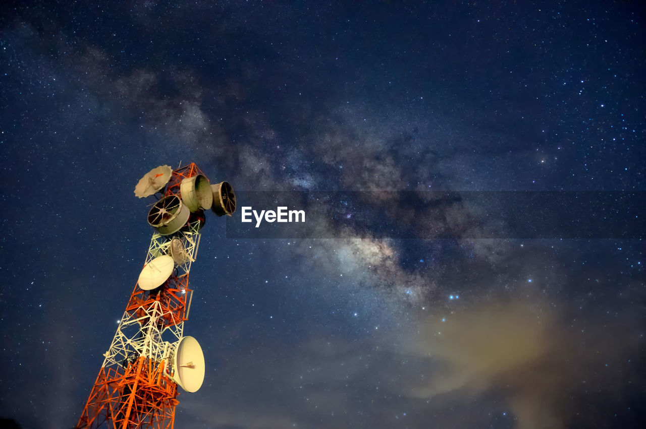 Telecommunication station at night with milky way background, transmission towers.