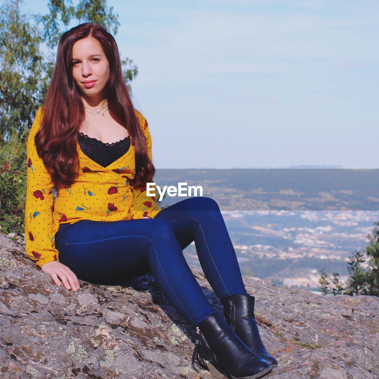 Portrait of beautiful young woman sitting outdoors
