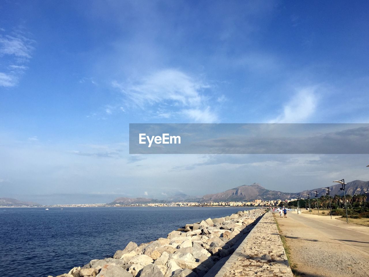 SCENIC VIEW OF SEA AND MOUNTAINS AGAINST BLUE SKY