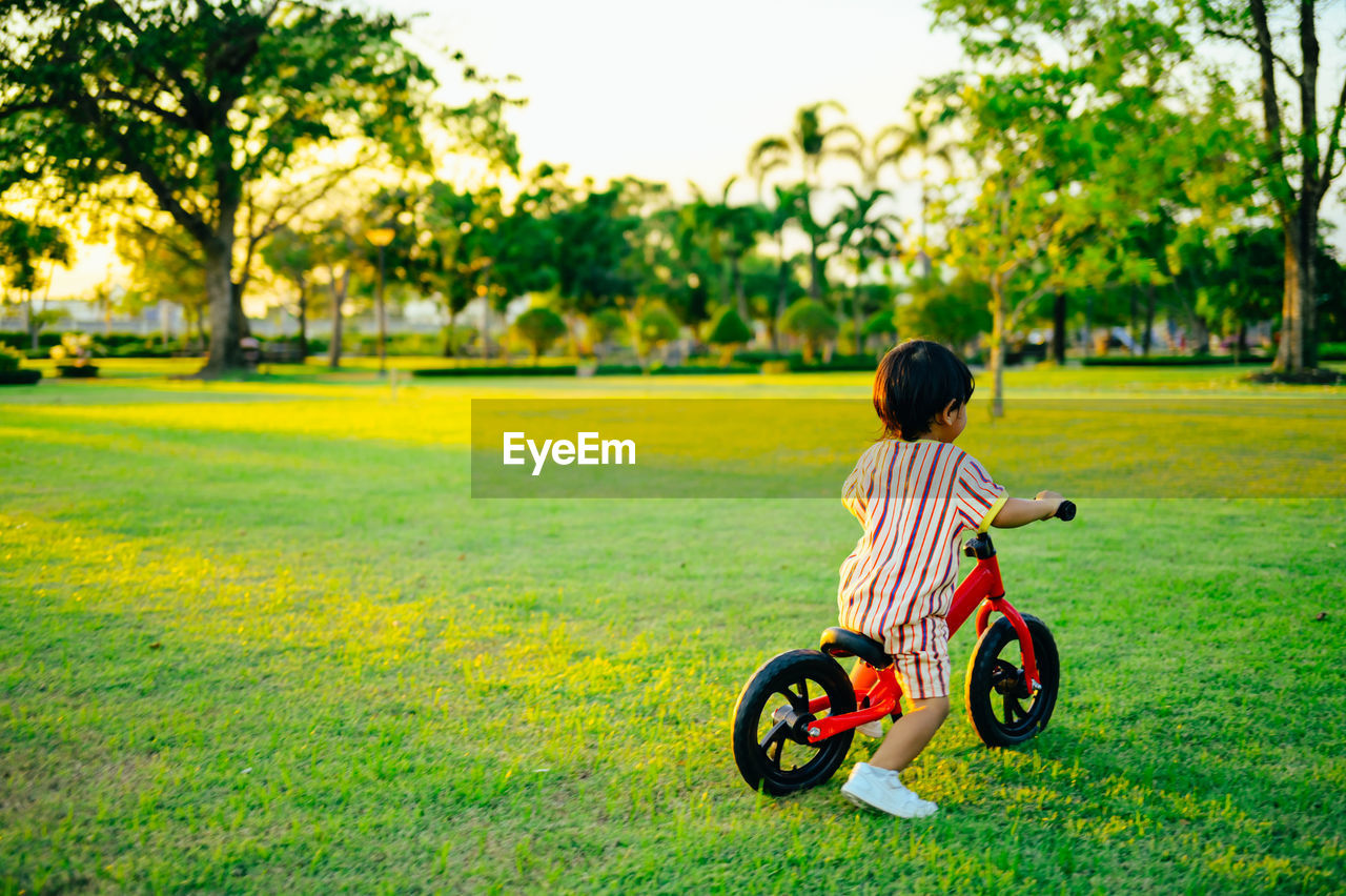 Rear view of boy playing with cycle