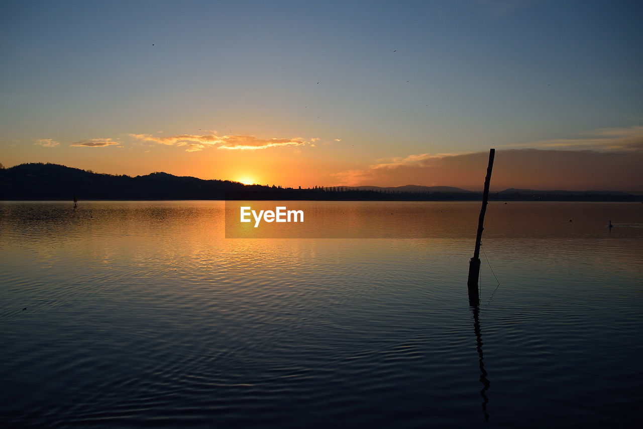 Scenic view of lake against sky during sunset