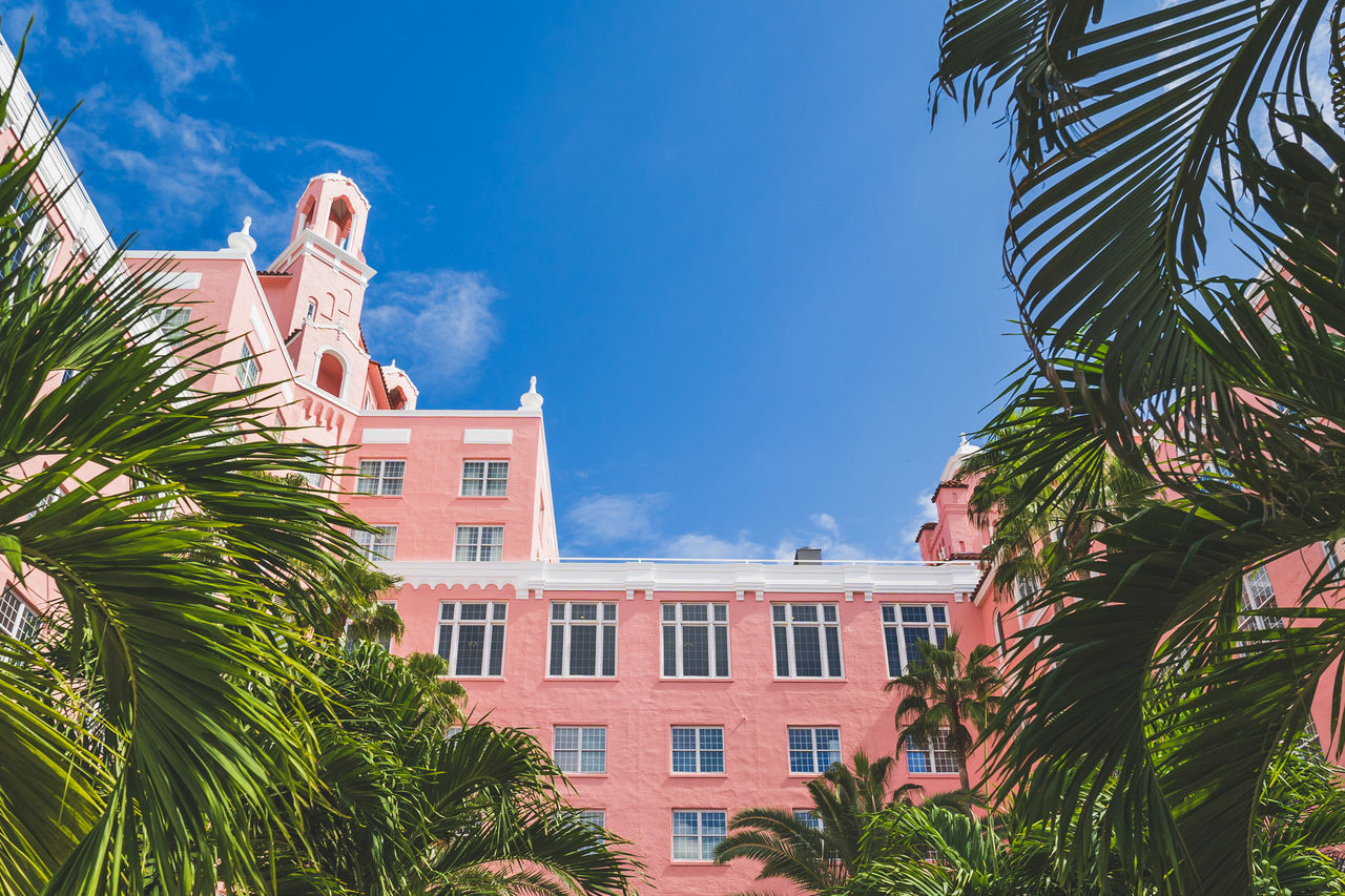 architecture, palm tree, building exterior, tree, built structure, tropical climate, plant, nature, sky, vacation, building, city, travel destinations, blue, resort, low angle view, residential district, day, outdoors, house, travel, landmark, no people, estate, sunlight