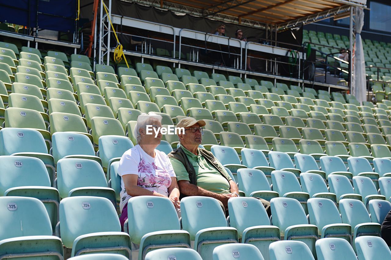 Couple sitting on chairs at auditorium