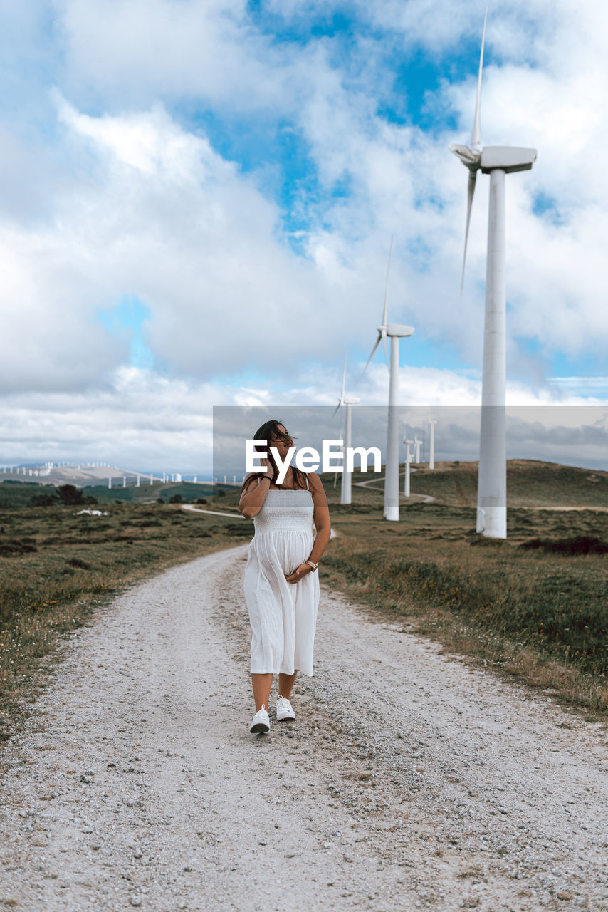 Full length of woman walking on field against sky