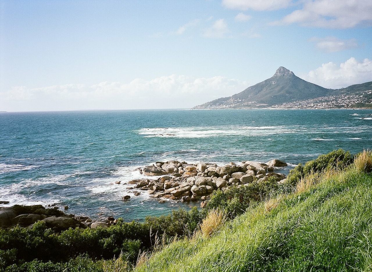 Scenic view of sea and mountain against sky