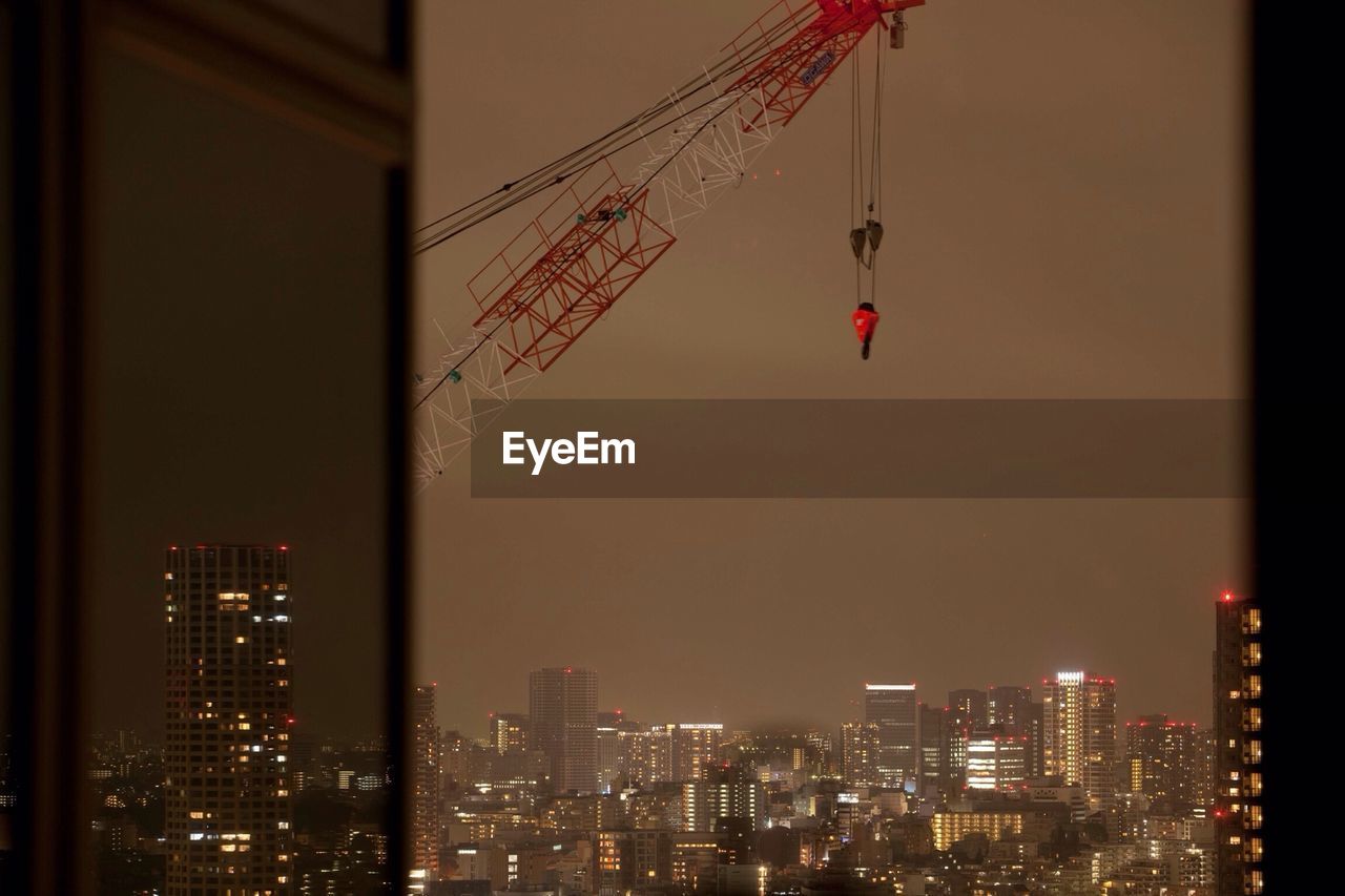 Crane and buildings seen through window