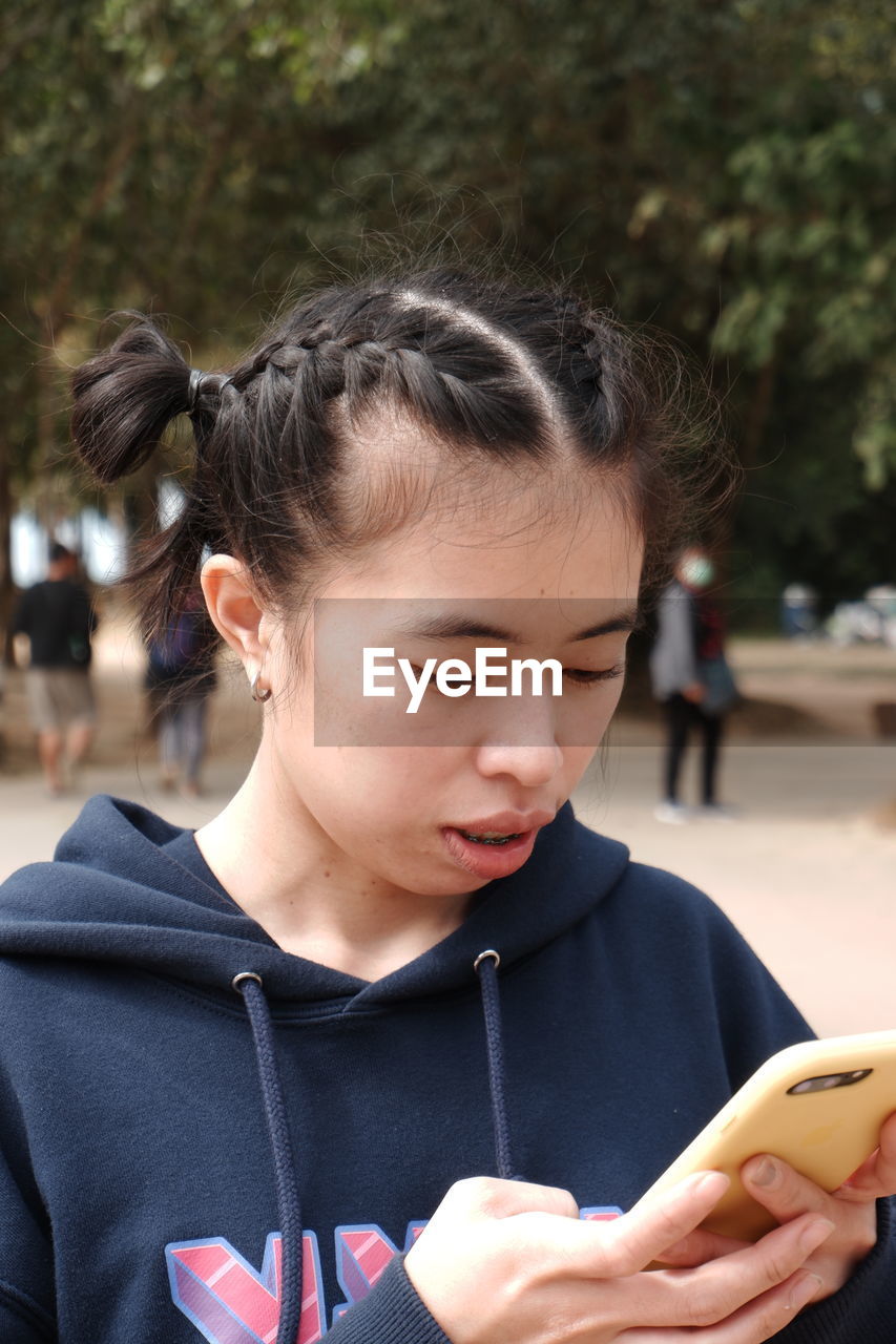 Close-up of young woman using smart phone in park