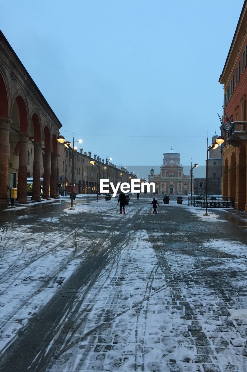 People walking on snow covered city in winter
