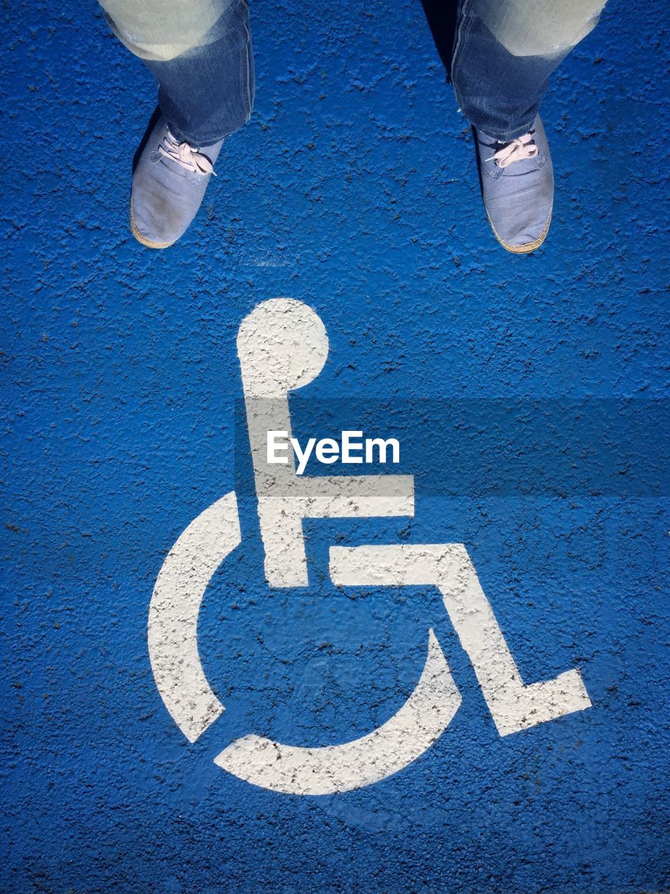Low section of man standing on disabled sign
