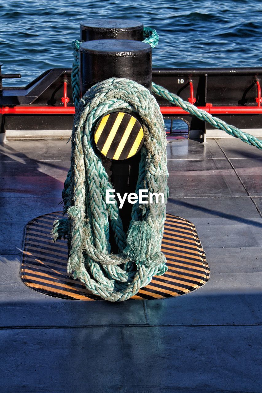 CLOSE-UP OF ROPE TIED TO PIER