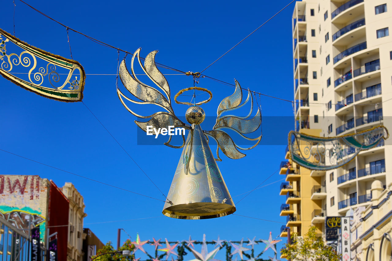 Decorations hanging against clear blue sky in city