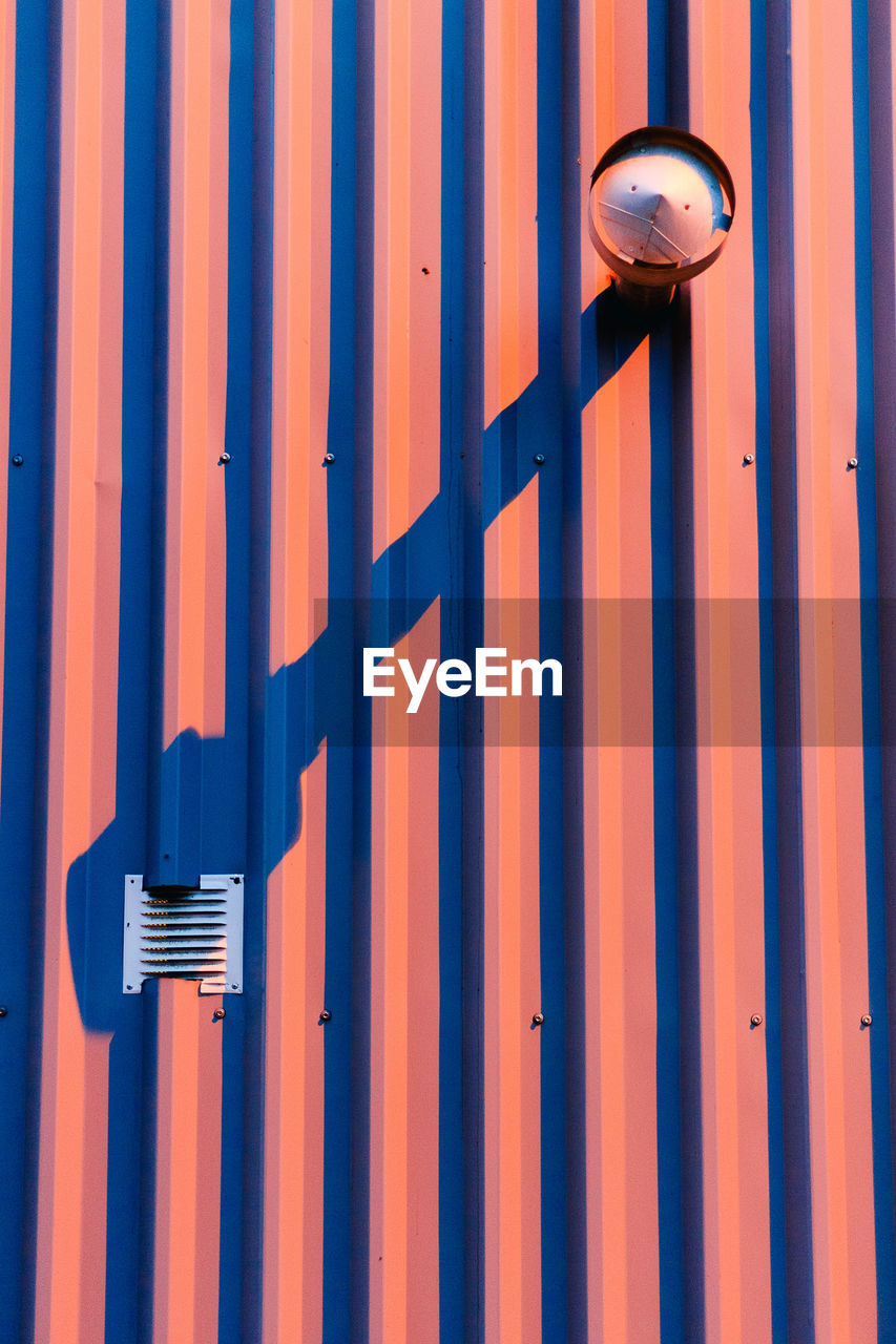 Close-up of metal gate against blue sky