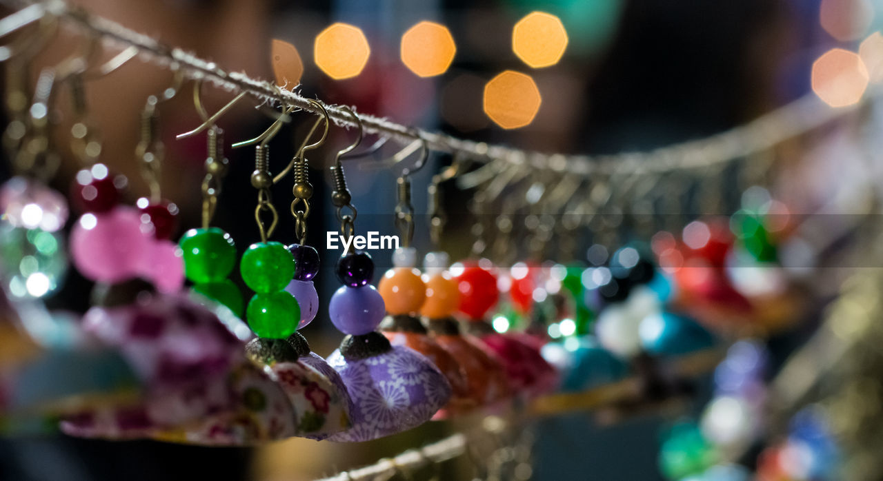 Close-up of colorful earrings hanging for sale at market