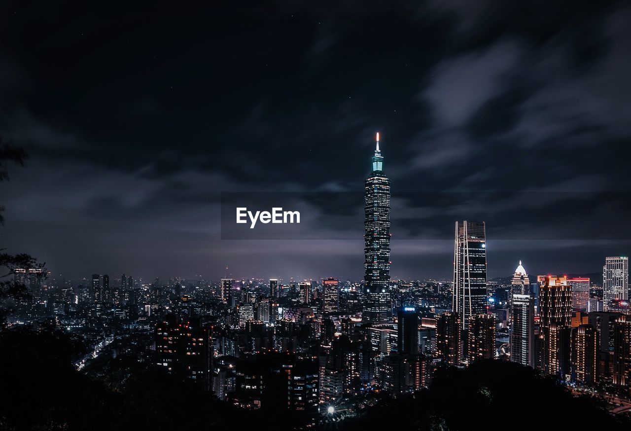 Illuminated Buildings Against Cloudy Sky At Night On Eyeem