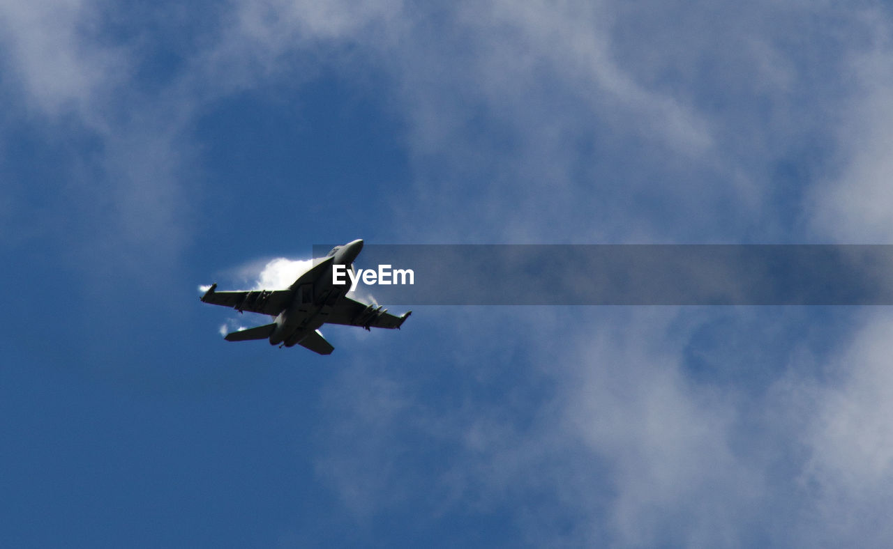 Low angle view of military airplane flying against sky