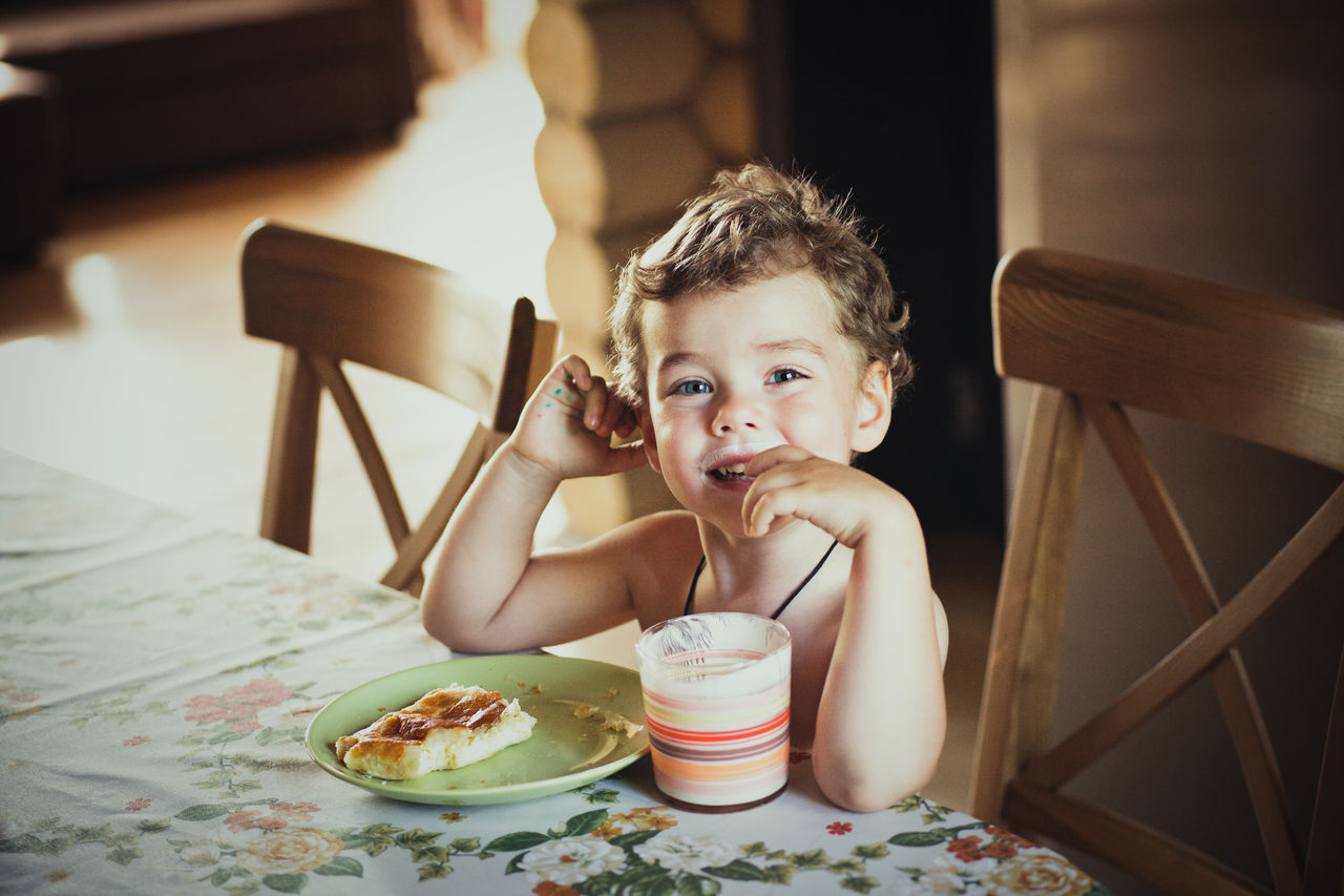 Portrait of boy having breakfast at table in home