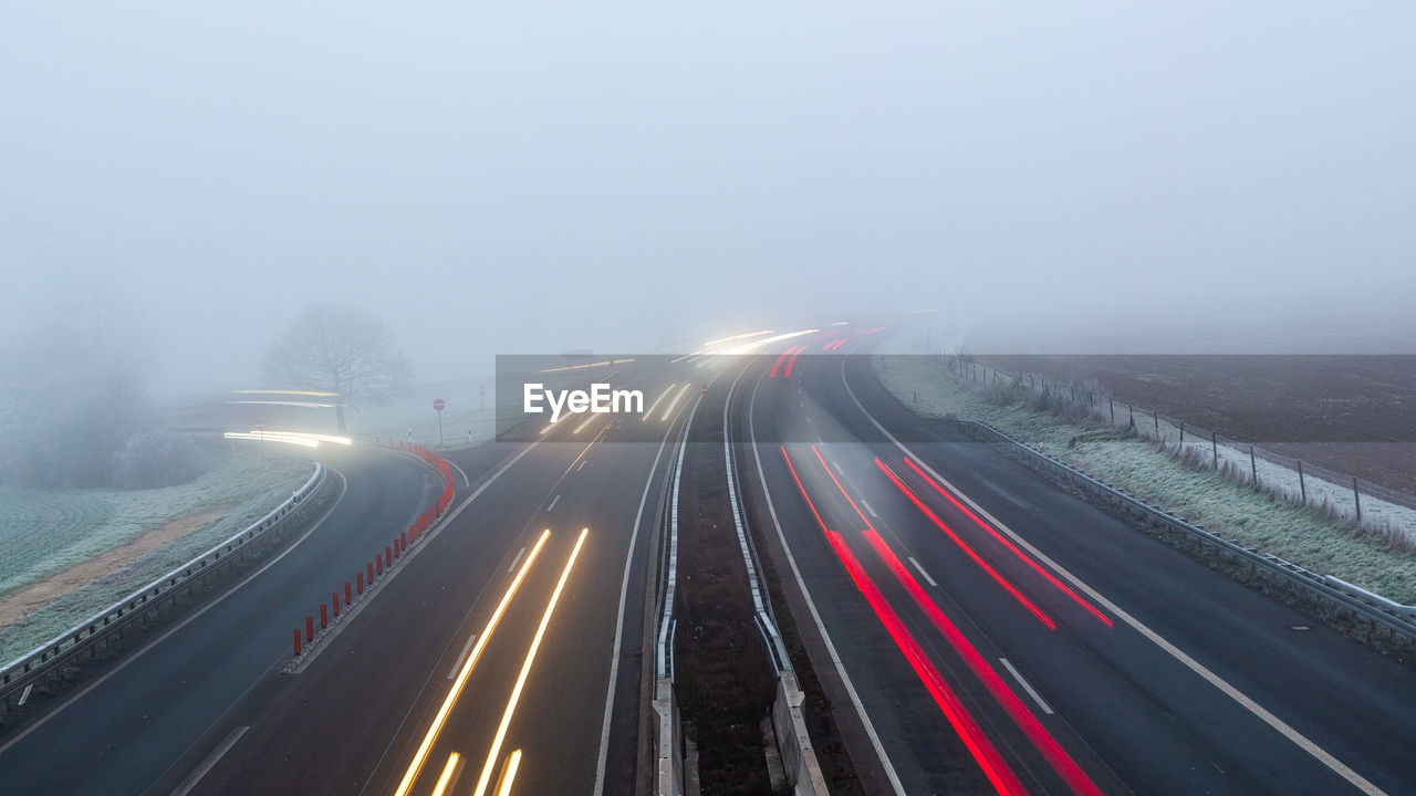 High angle view of light trails on foggy autobahn