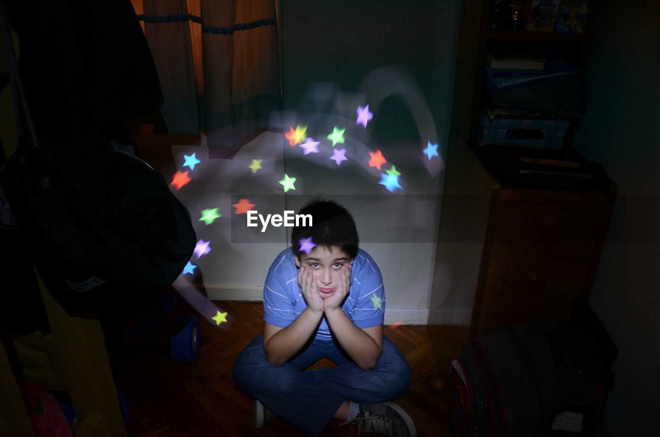 Portrait Of Sad Boy Against Star Shape Light Id 73009171