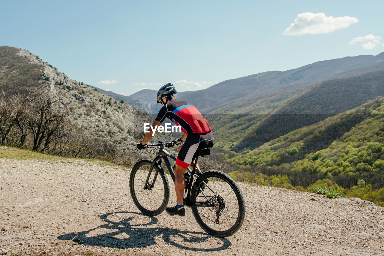 Athlete cyclist riding mountain bike on mountain trail