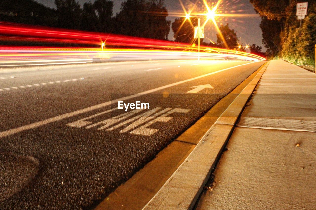 BLURRED MOTION OF LIGHT TRAILS ON ROAD AT NIGHT