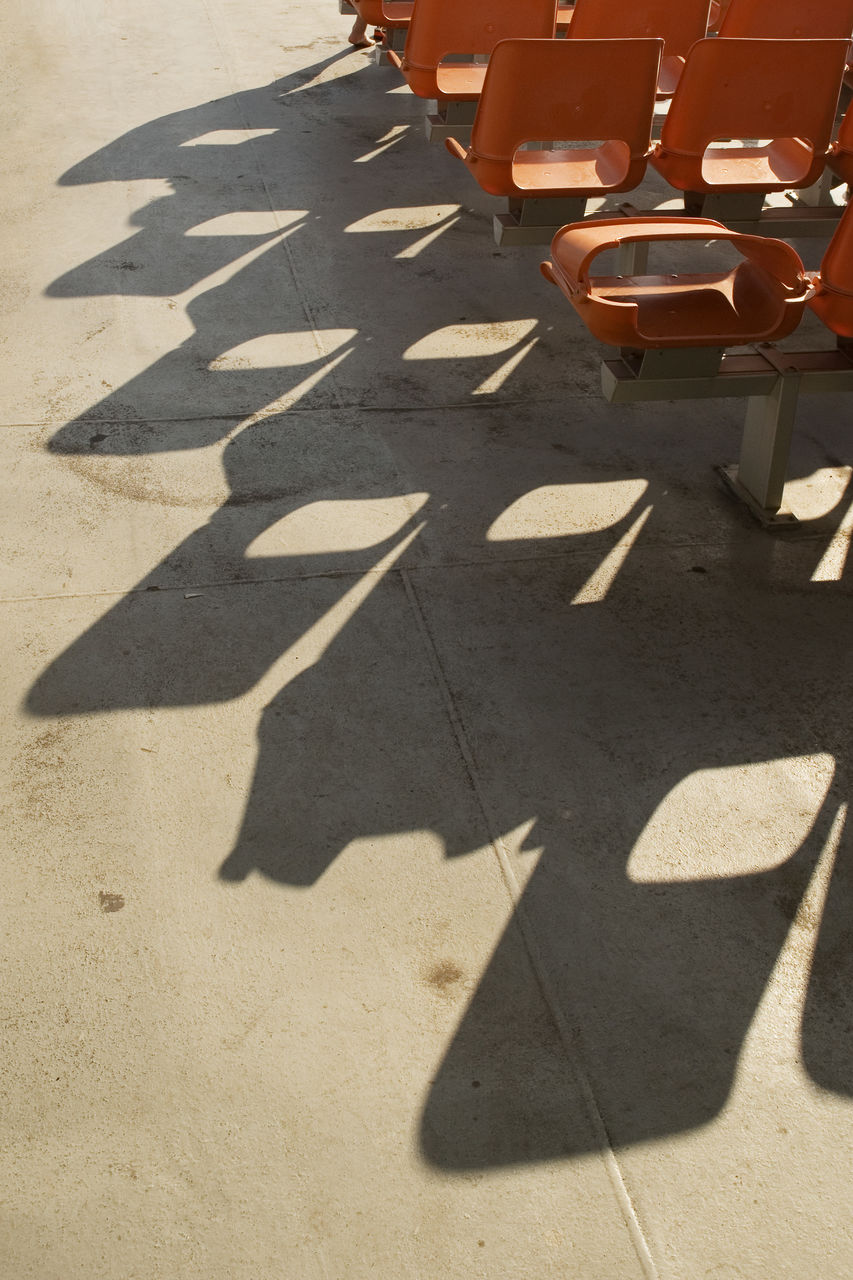 Orange seats by street on sunny day