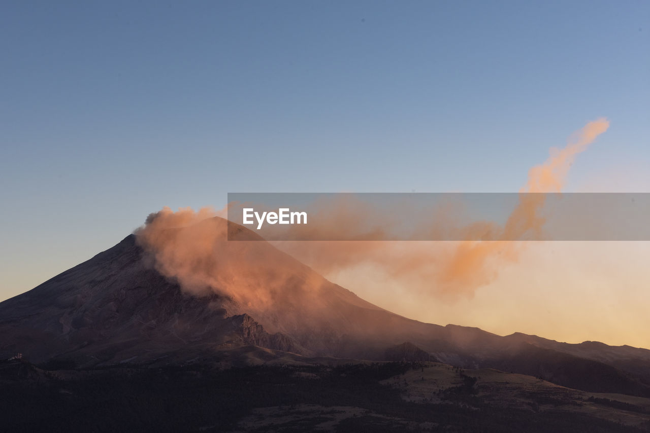 Popocatlepetl volcano smoking at sunset