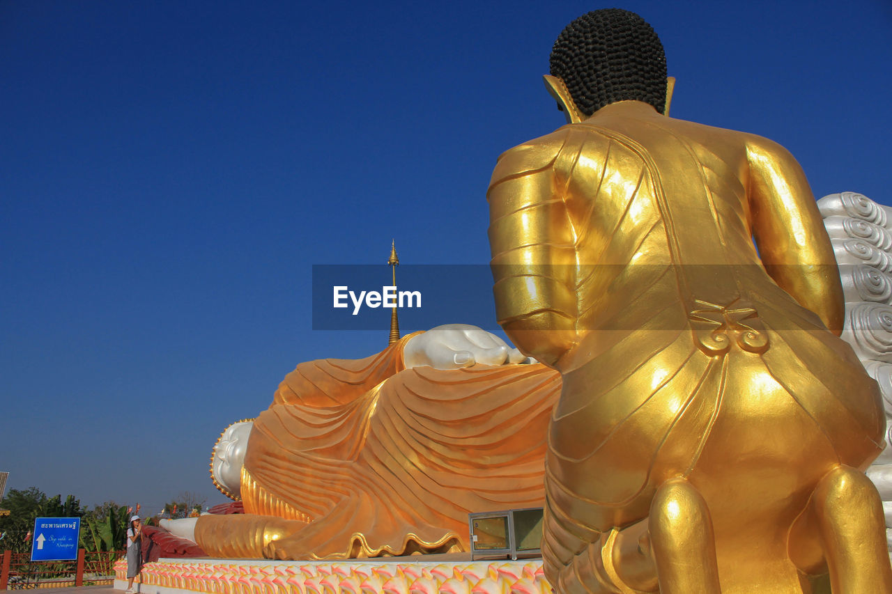 BUDDHA STATUE AGAINST BLUE SKY
