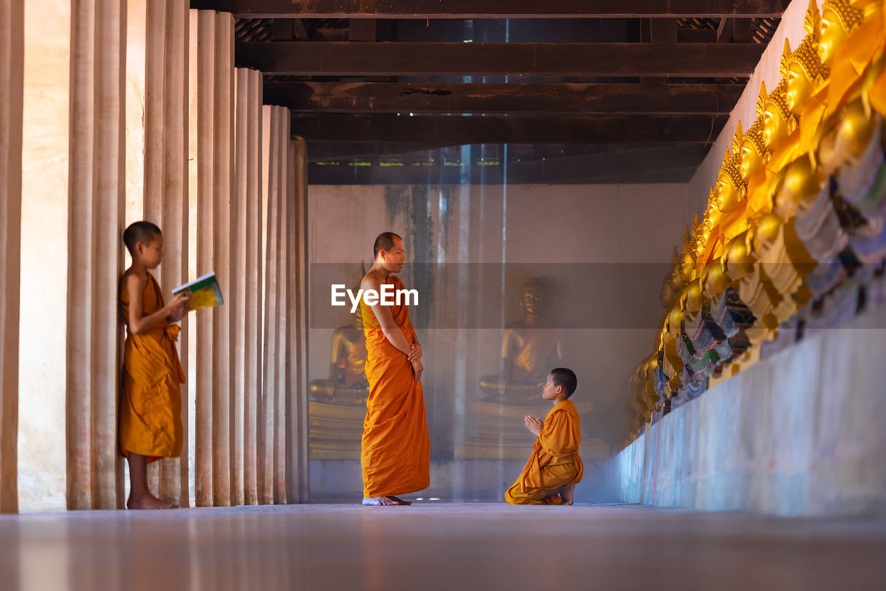 Monk teaching boy in buddhist temple