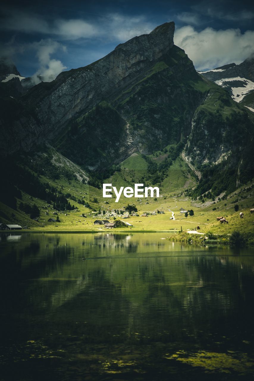 Scenic view of lake by mountain against sky