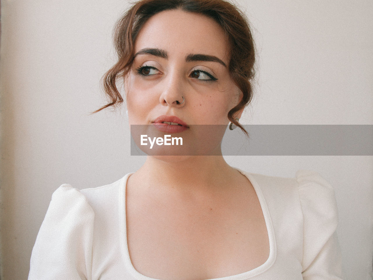Close-up portrait of young woman against wall