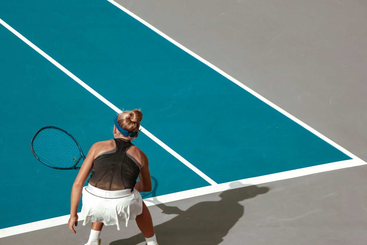 Rear view of girl playing tennis