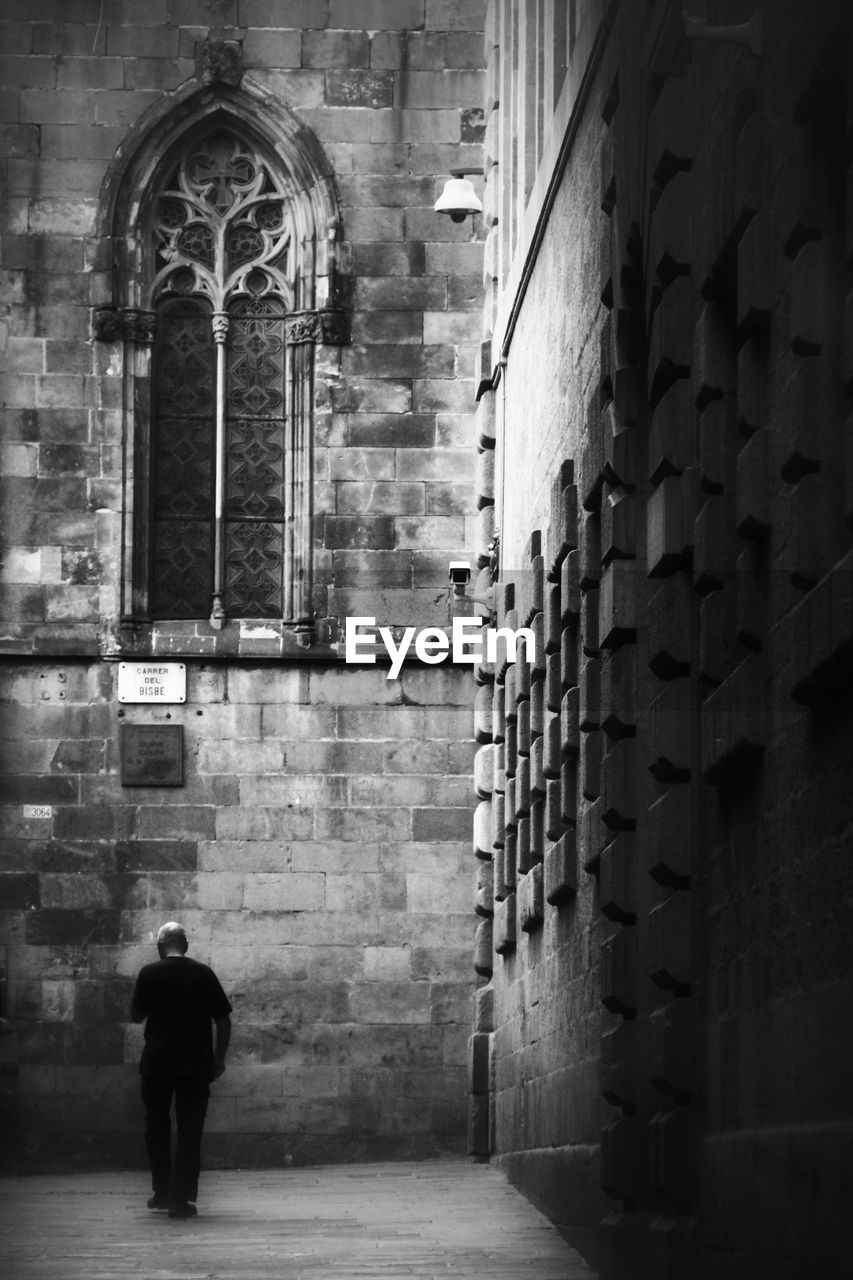 Full length rear view of man at gothic quarter
